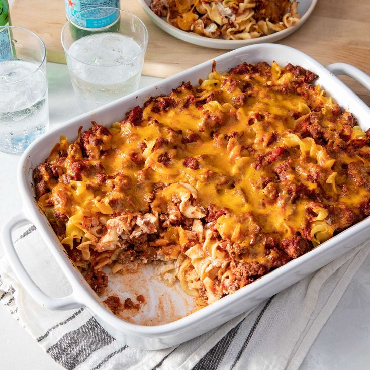 a casserole dish with meat, cheese and pasta in it on a table