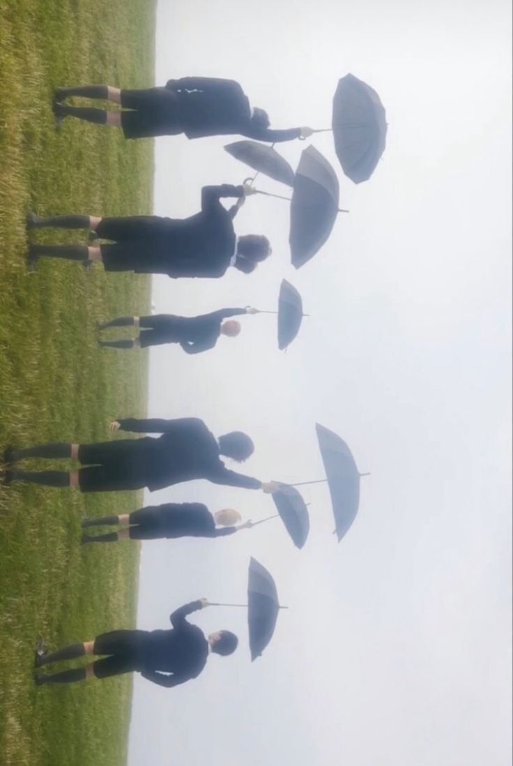 a group of people standing on top of a grass covered field next to each other