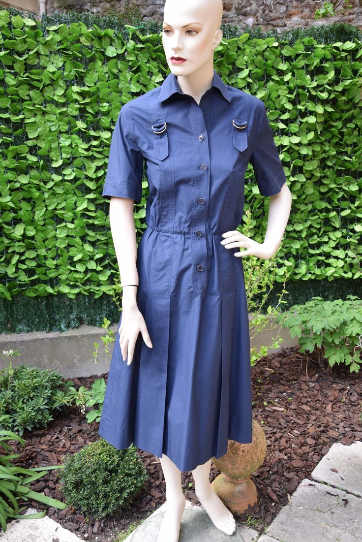 Nice classical navy blue poeppeline cotton shirt dress with short sleeves embellished with a strap motif which begins and ends at back in two inverted pleats, the chest adorned with two metal buckles. Closure by signed buttons. French size 38, American 6, International M. Very good vintage condition. More pictures on my website www.that-little-pink-shop.fr No discount. Free worldwide shipping with tracking and insurance. No returns, including EEC customers. Please contact if you have a problem w Classic Pleated Short Sleeve Shirt Dress, Classic Pleated Shirt Dress With Short Sleeves, Fitted Shirt Dress With Pockets For Formal Occasions, Classic Short Sleeve Dress With Button Cuffs, Formal Cotton Dress With Buttons, Formal Cotton Dresses With Pockets, Formal Short Sleeve Buttoned Dress, Formal Short Sleeve Shirt Dress With Button Cuffs, Formal Short Sleeve Dress With Buttons