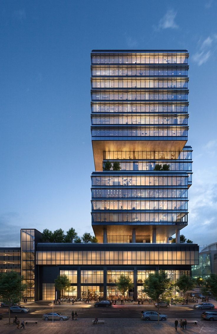 a tall building with lots of windows next to a parking lot in front of it