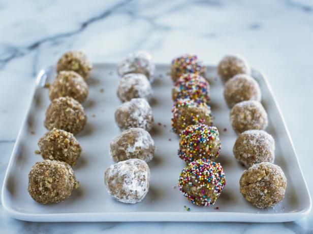 several different types of doughnuts on a white tray with sprinkles