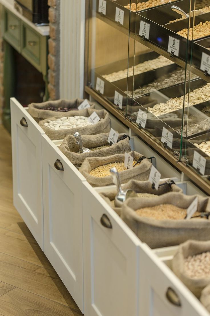 an assortment of cereals and grains on display in a store case with tags hanging from the sides