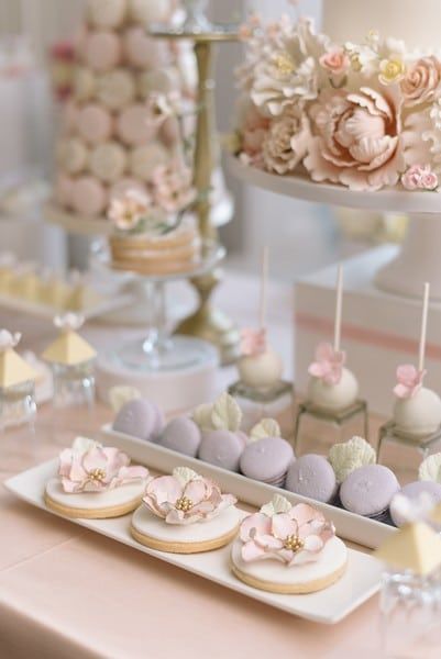 there are many desserts on the table with pink and white flowers in them,