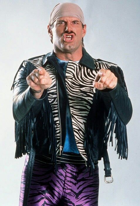 a man dressed in zebra print pants and a leather jacket pointing his finger at the camera