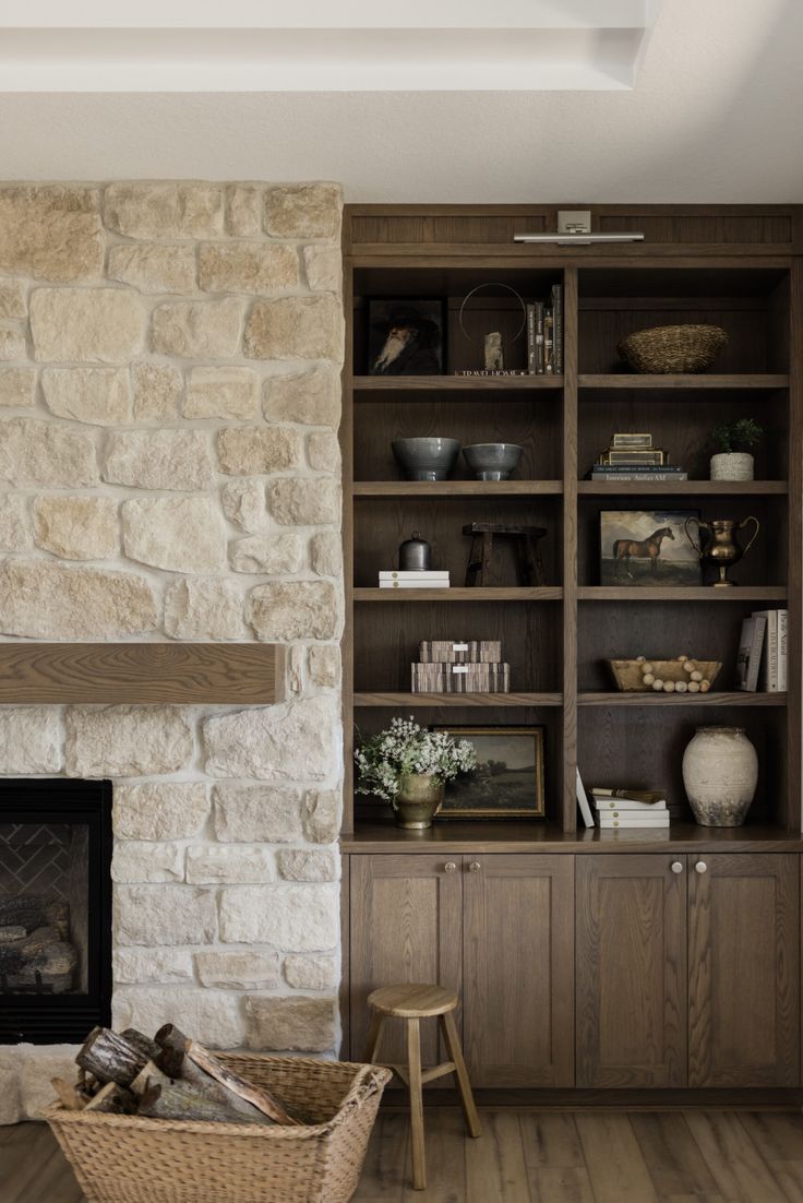 a living room filled with furniture and a fire place in front of a stone fireplace