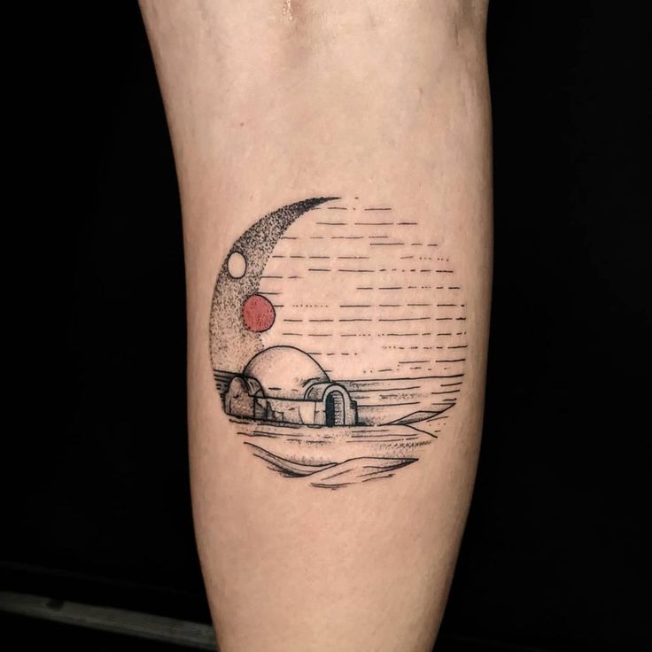 a tattoo on the leg of a person with a house and moon in the background