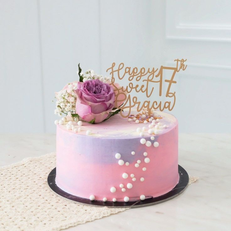 a pink and purple cake with a rose on top