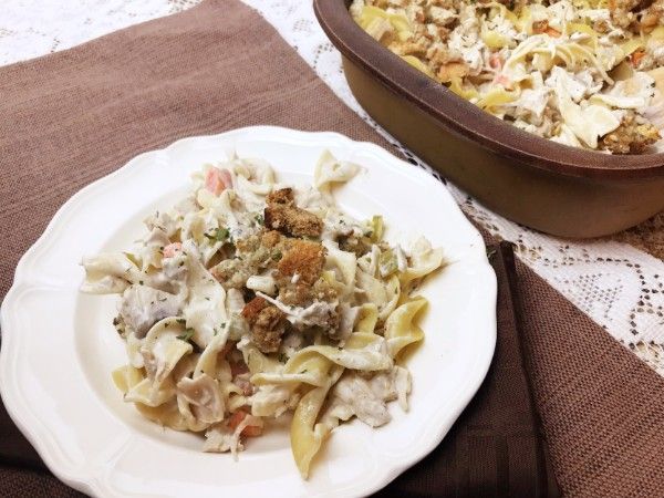 a white plate topped with pasta next to a casserole dish on a table