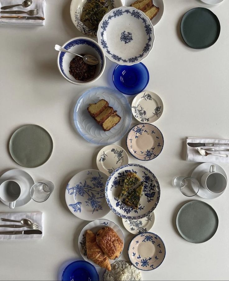 a table topped with plates and bowls filled with different types of food on top of it