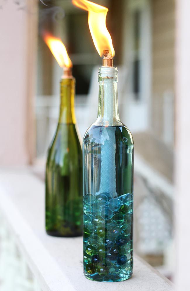 two empty bottles with water inside sitting on a window sill