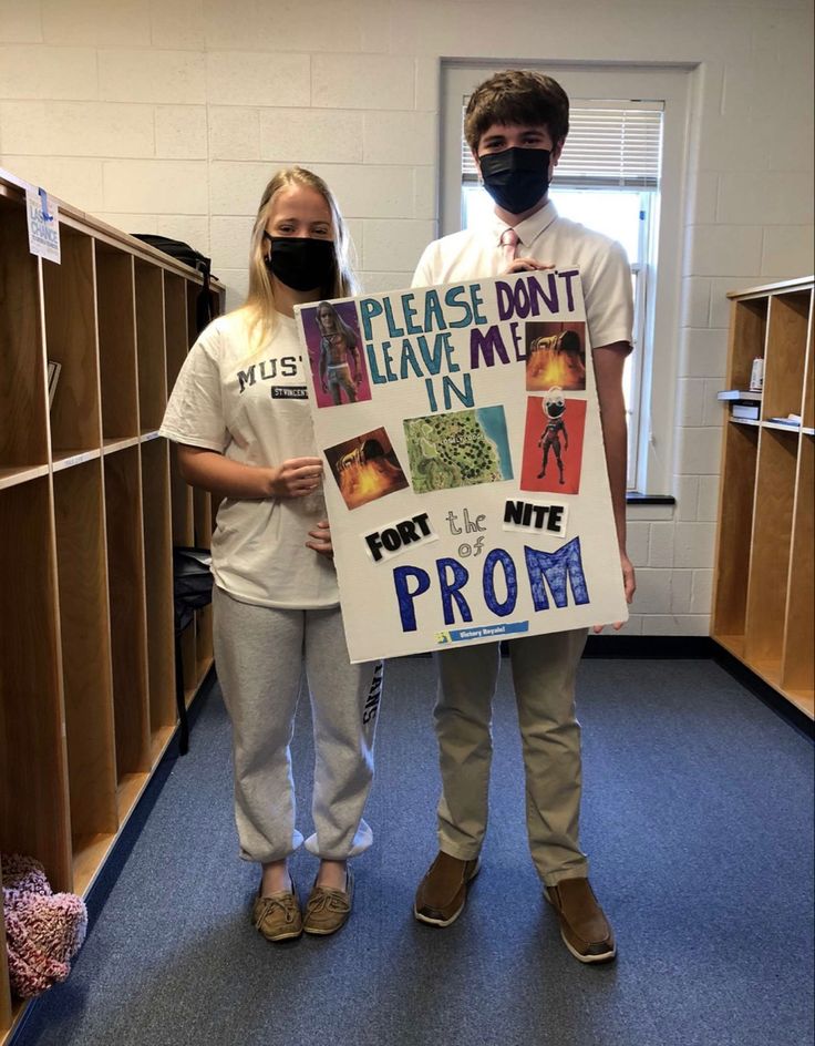 two people standing next to each other wearing masks and holding a sign that says please don't leave me in front of them