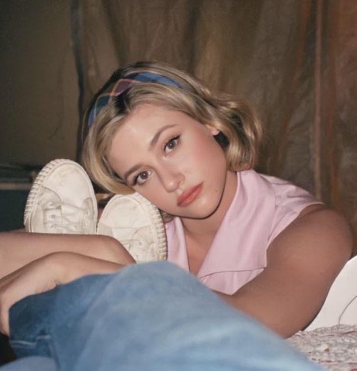 a young woman laying on top of a bed