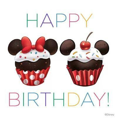 two mickey mouse cupcakes with white frosting and red bows on top, one has a cherry in the middle