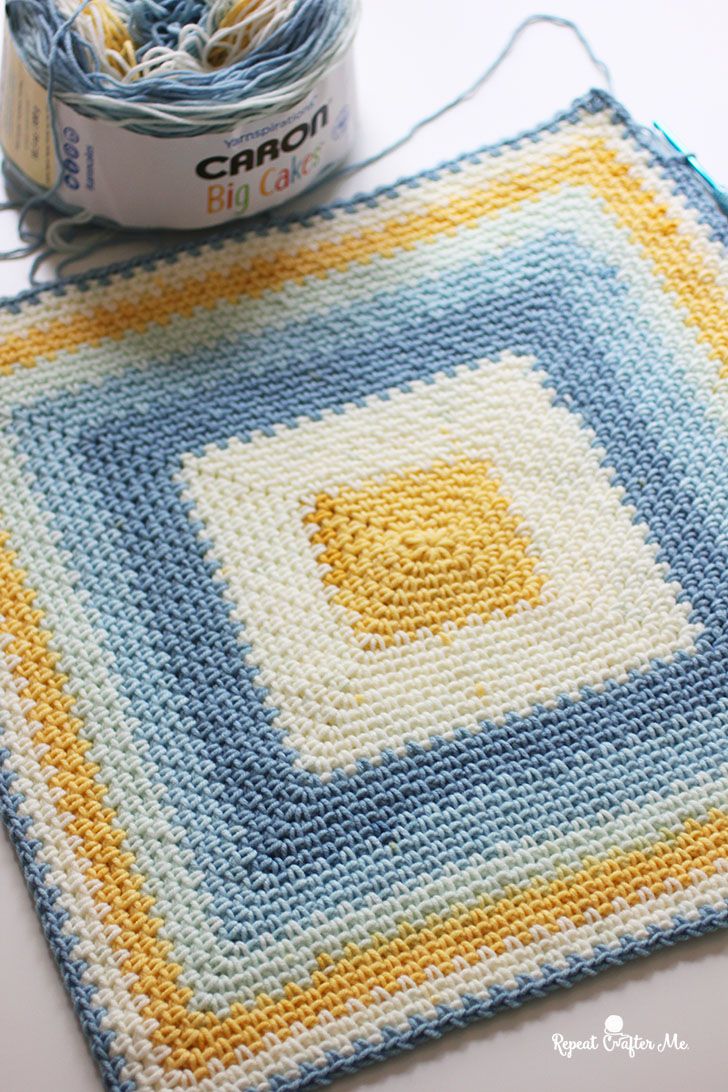 a crocheted square with yarn next to it