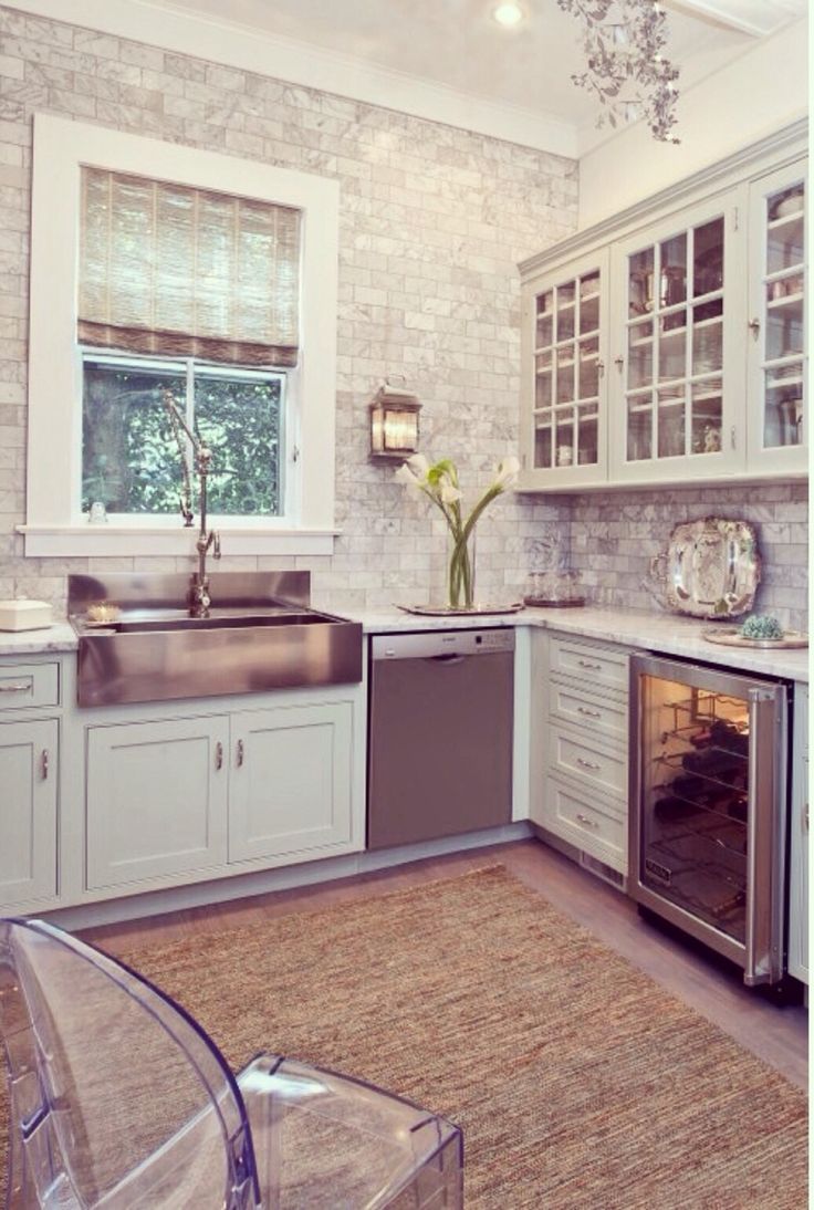 a kitchen with white cabinets and silver appliances