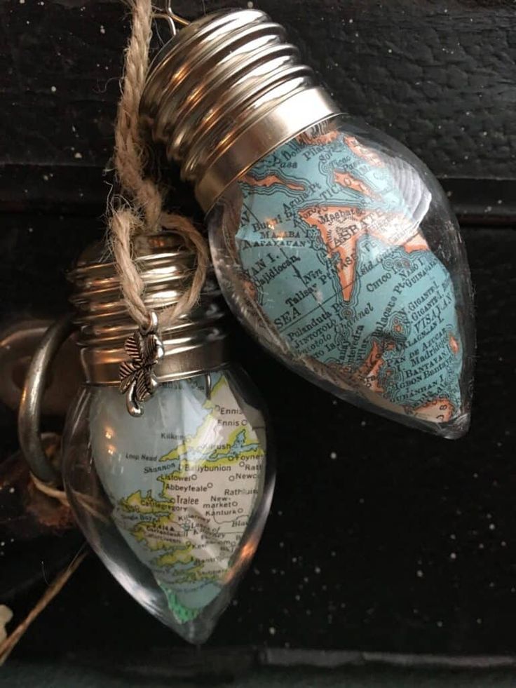 two heart shaped bottles are hanging from a string on a doorknob with a map in it