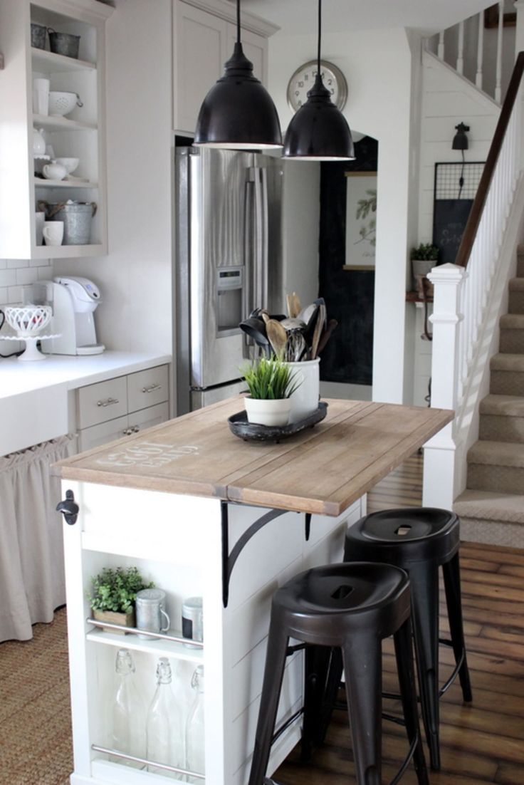 a kitchen island with two stools in front of it and an open door leading to the second floor