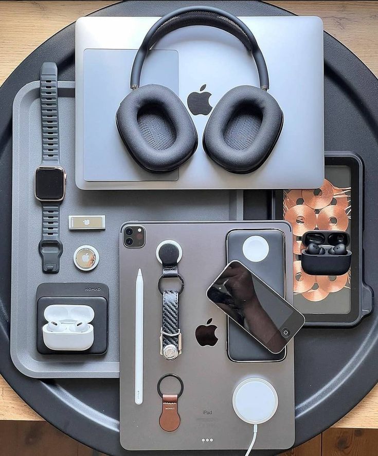 an assortment of electronics and gadgets are arranged on a metal tray, including headphones