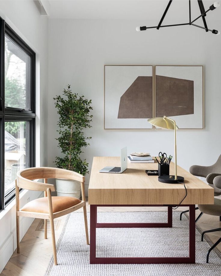 an office with a desk, chair and large window