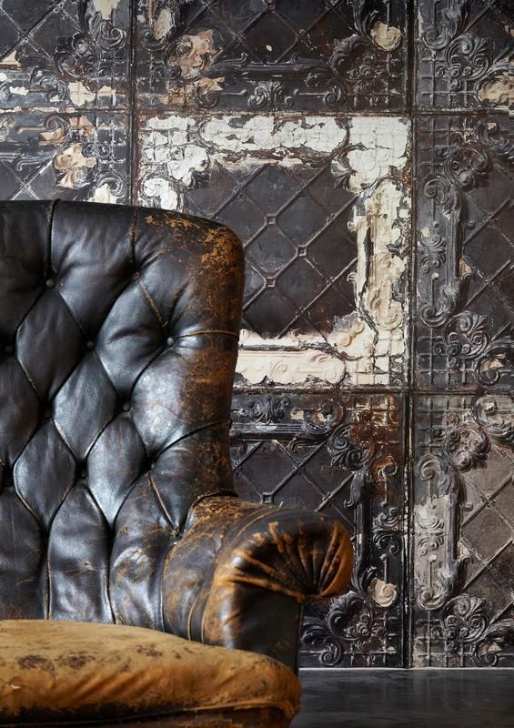 an old leather chair sitting in front of a wall