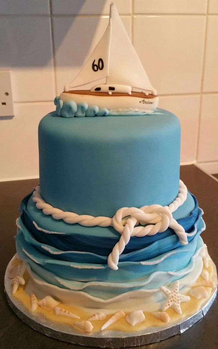 a blue and white cake with a sailboat on top