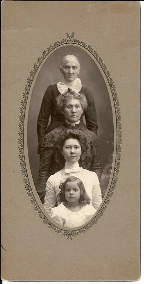 an old photo of three women and one child