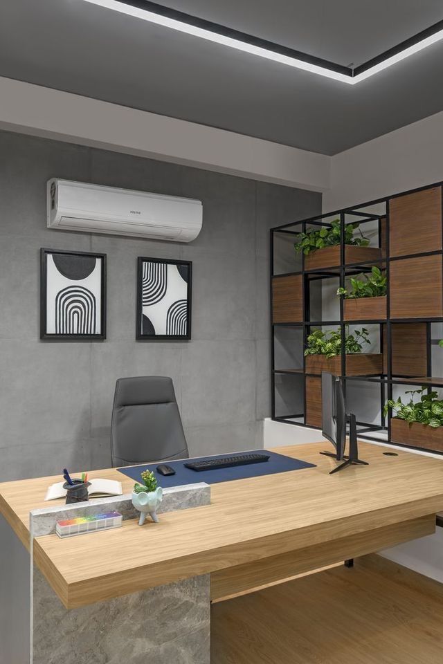 an office with a desk, chair and air conditioner on the wall next to it