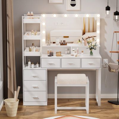 a white vanity with lights on it in a room next to a chair and rug