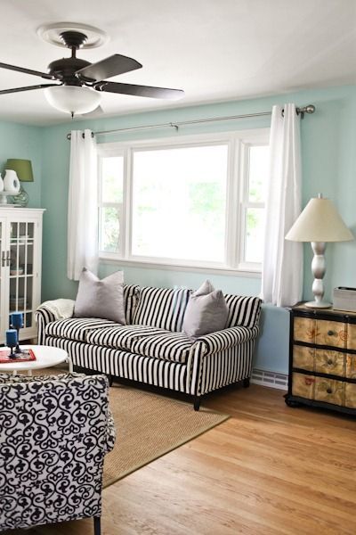 a living room filled with furniture and a fire place next to a window on top of a hard wood floor