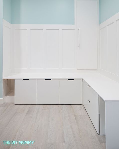 an empty room with white cabinets and drawers