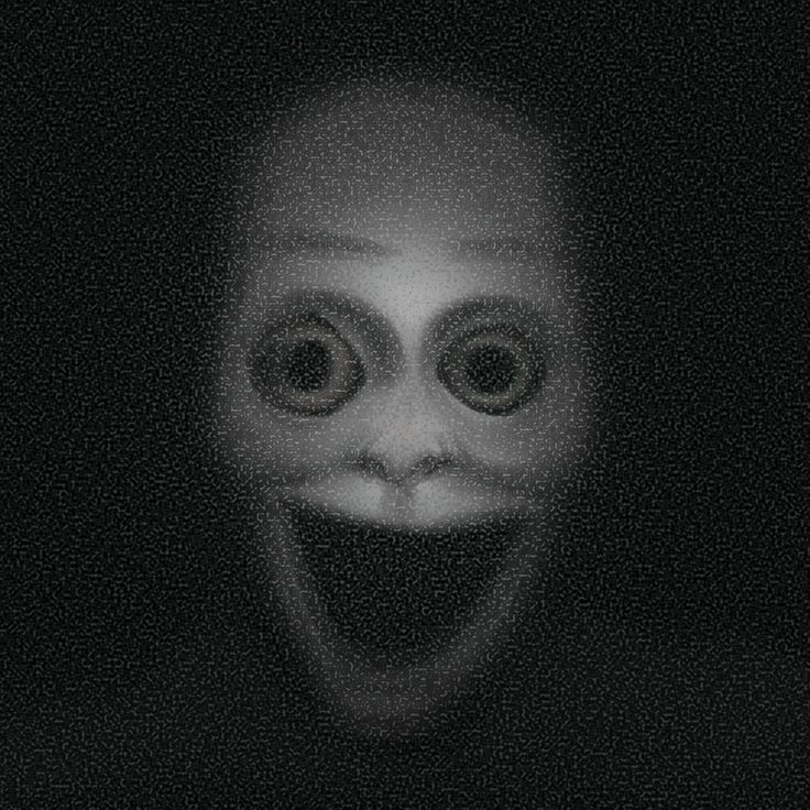 a creepy face is seen in the dark