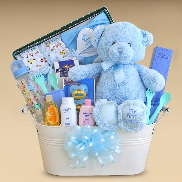 a blue teddy bear sitting in a white basket filled with baby care products and personal care items