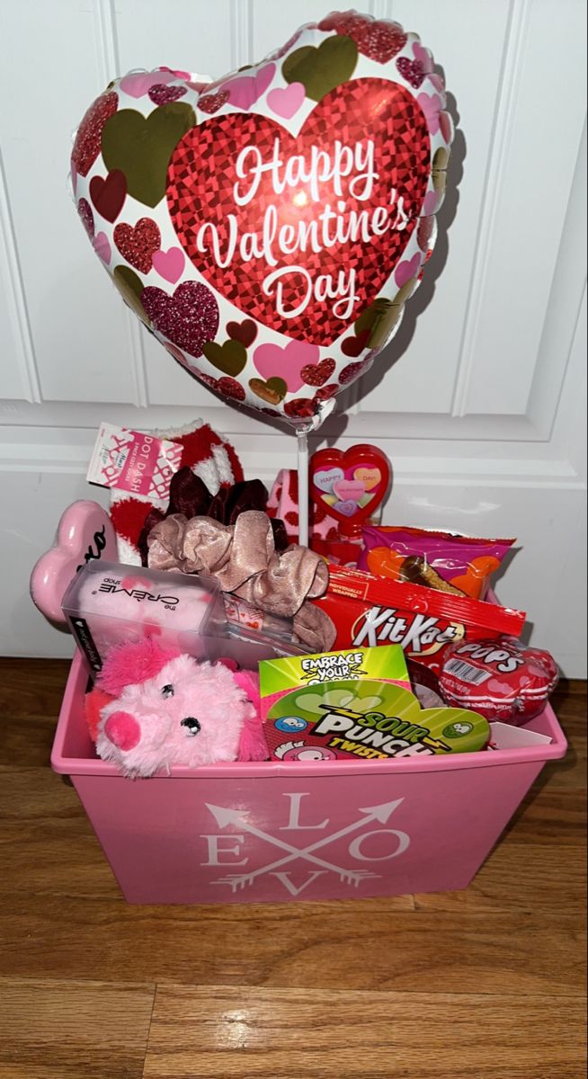 a valentine's day gift basket with candy, candies and heart shaped balloon