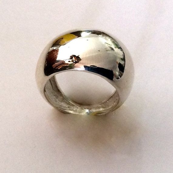 a silver ring sitting on top of a white table next to a black and yellow object