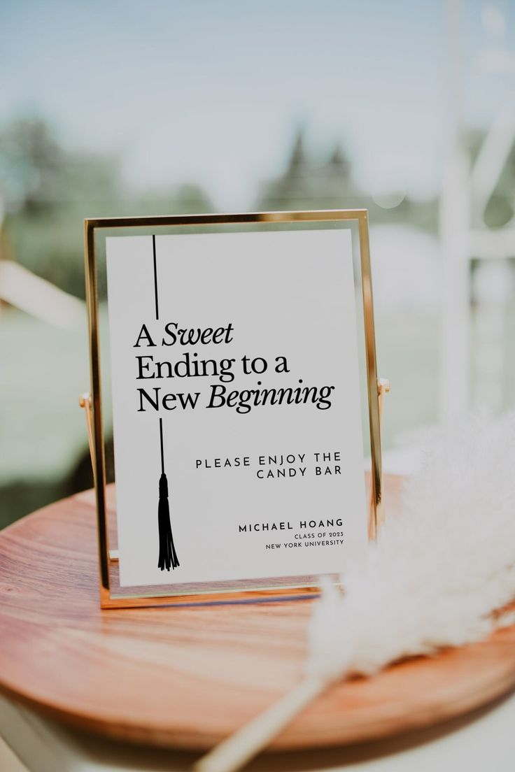 a book sitting on top of a wooden table next to a white feather and a sign