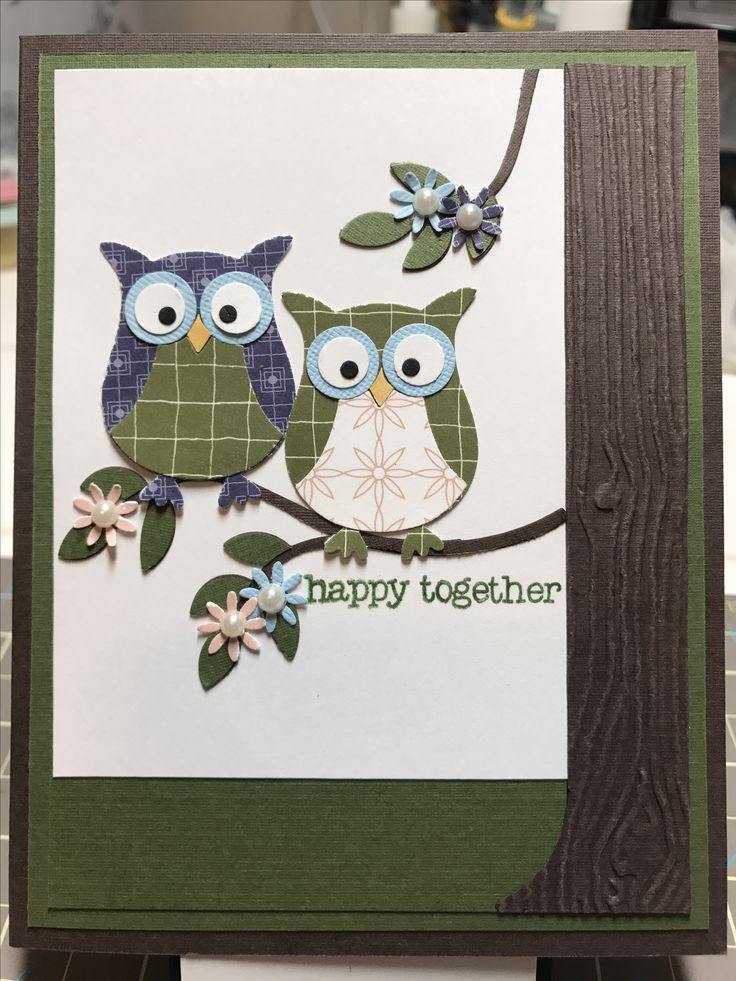 two owls sitting on a tree branch with the words happy together in green and blue