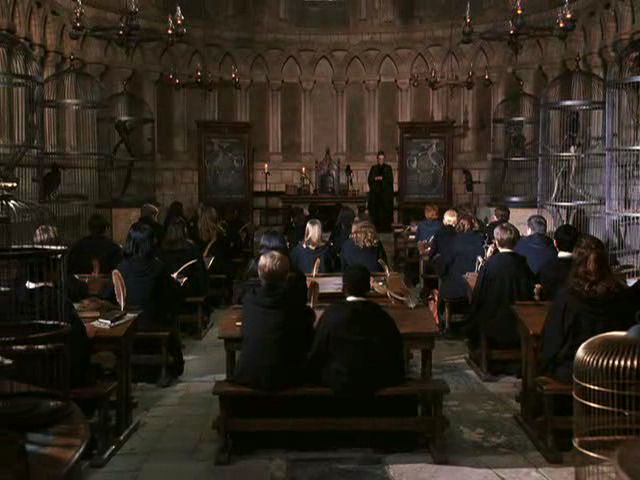 a group of people sitting at desks in a room filled with books and papers