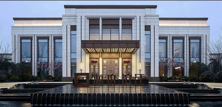 the front entrance to a modern building with water fountain