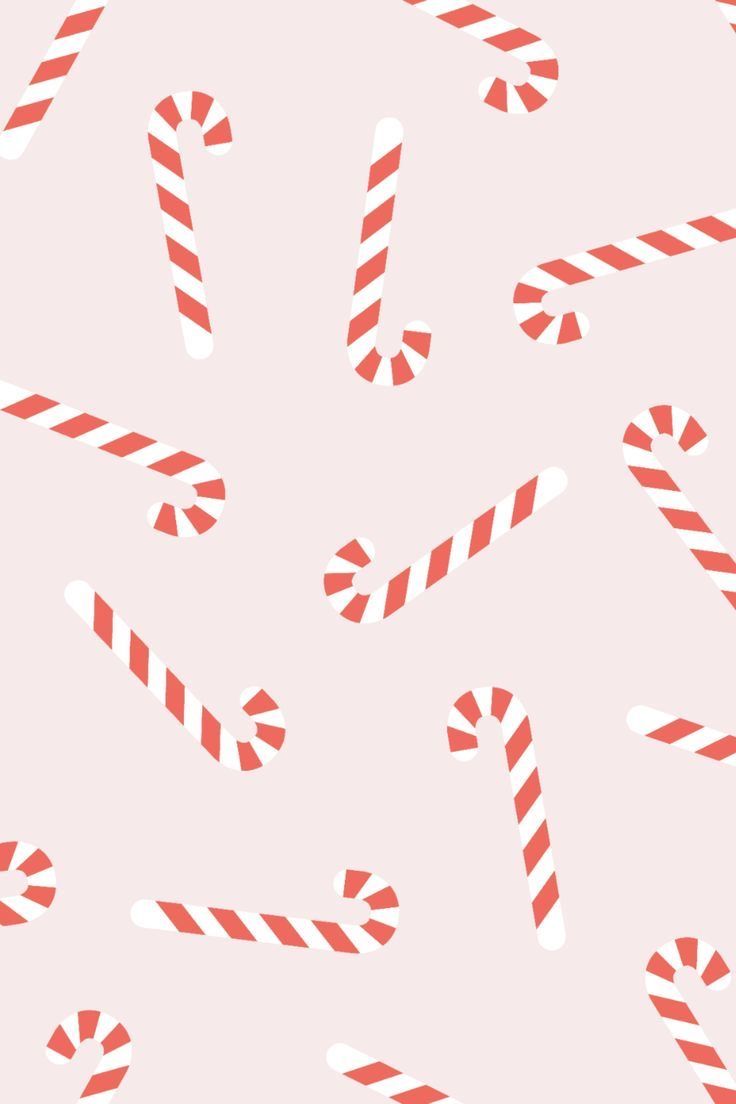 red and white candy canes are scattered on a light pink background with diagonal stripes