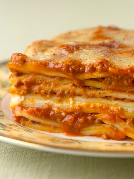 a stack of lasagna stacked on top of each other with cheese and sauce