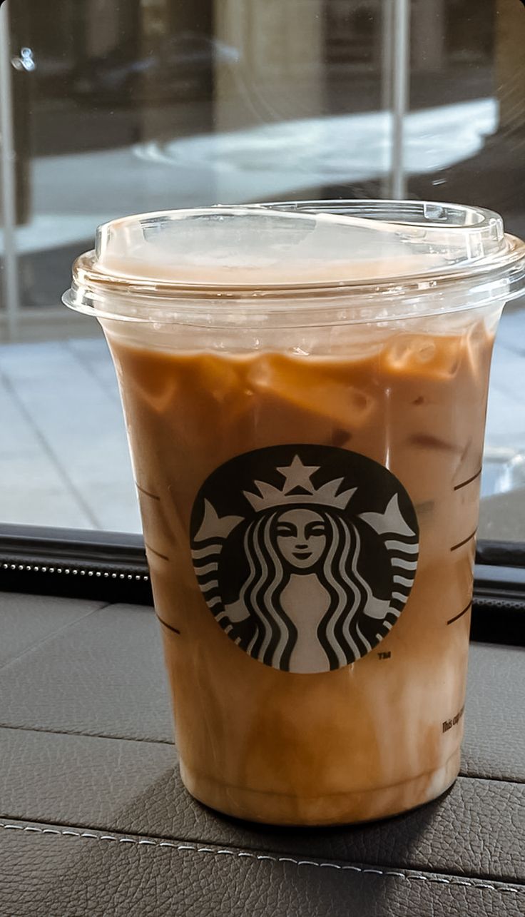 a cup of iced coffee sitting on top of a table