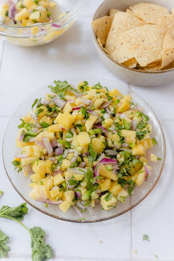 a plate full of pineapple salsa with tortilla chips and guacamole