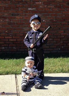 two children dressed up as police officers, one holding a bat and the other sitting down