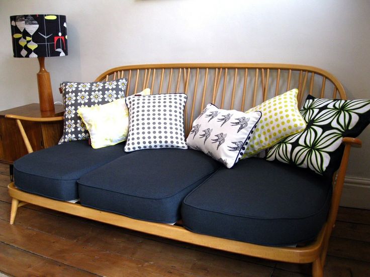 a wooden couch with many pillows on it