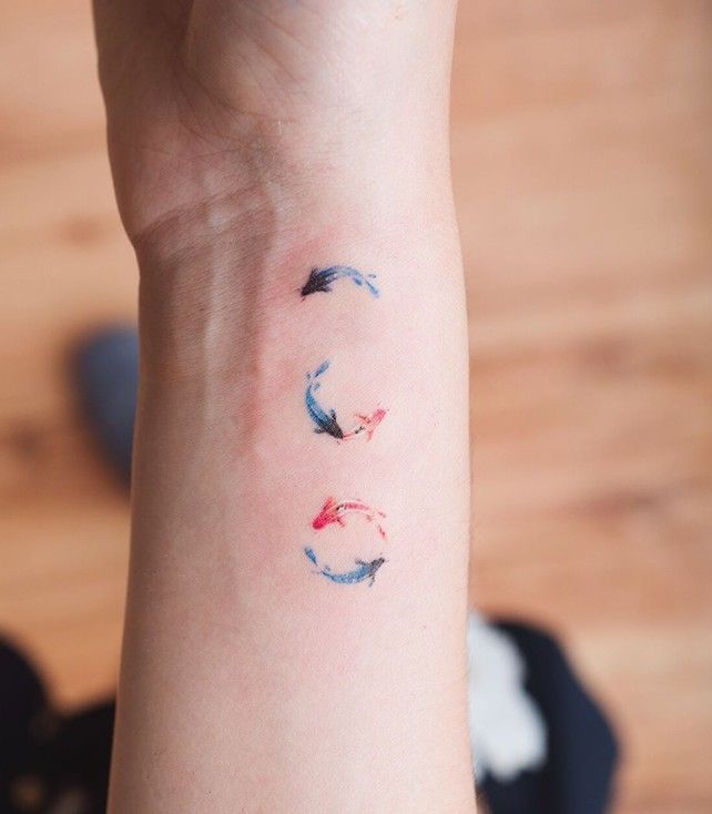 a woman's arm with three different colored arrows on the left side of her wrist