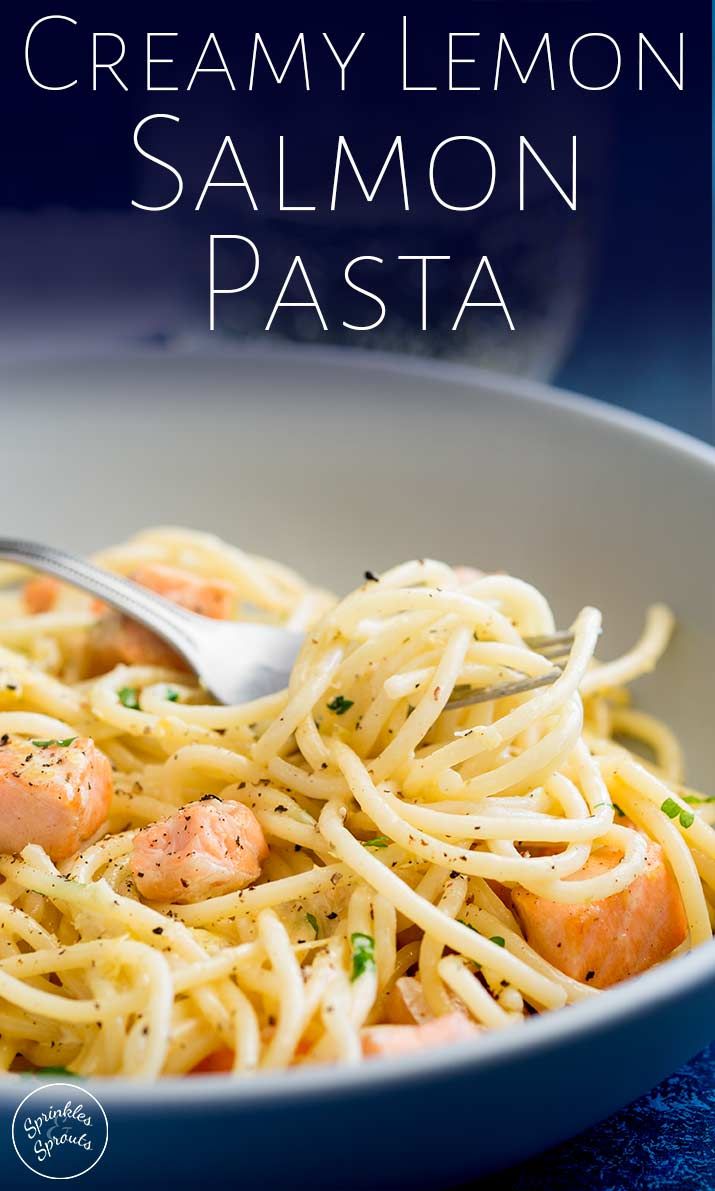 a white bowl filled with pasta covered in creamy lemon sauce and topped with shrimp