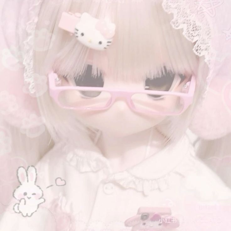 a white doll with pink glasses and a hello kitty hair clip on it's head