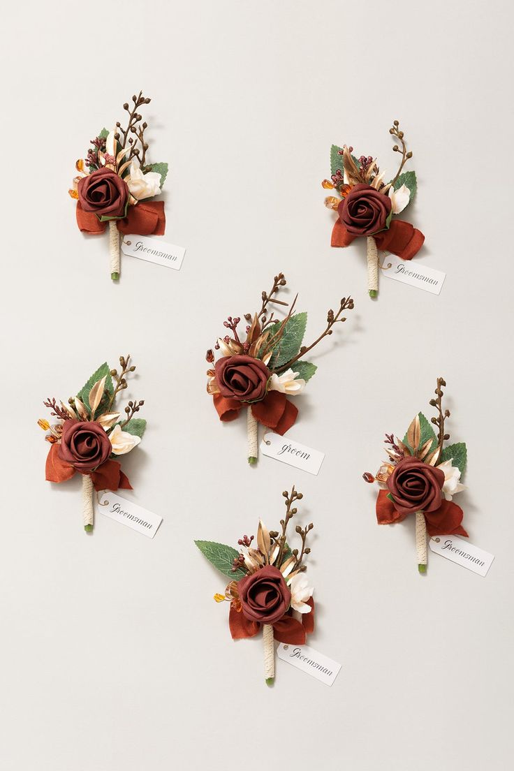 four boutonniers with flowers and leaves on them