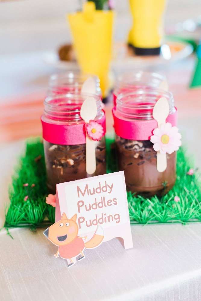 two mason jars filled with muddy puddings sitting on top of green grass next to flowers