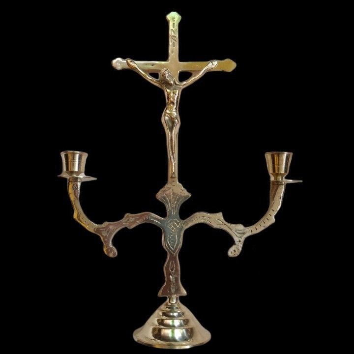 a crucifix with three candles on it